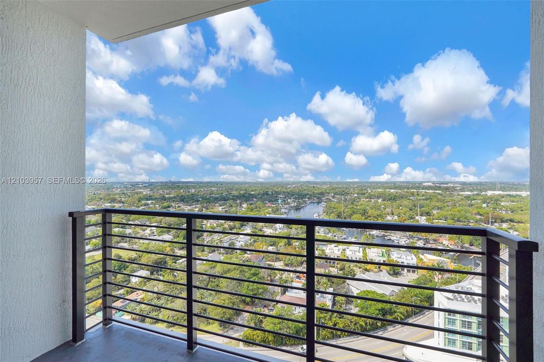 Balcony featuring a metal railing and a high-rise perspective