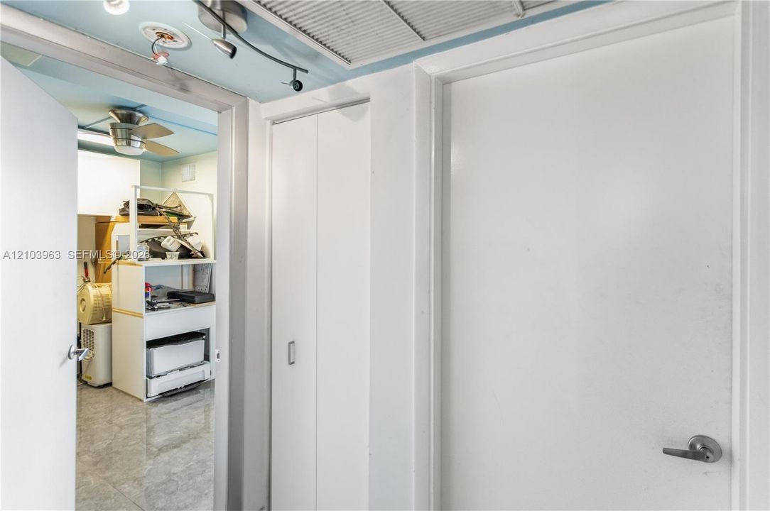Interior space featuring flat-panel doors, bi-fold closet doors, tile flooring, and a ceiling-mounted fan