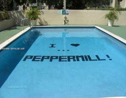 In-ground swimming pool with metal ladder access, a concrete deck, and perimeter masonry walls