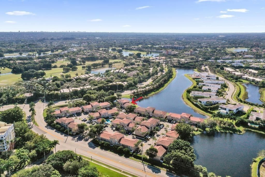 Aerial perspective of a multi-unit property featuring clay tile roofing and waterfront positioning along a lake