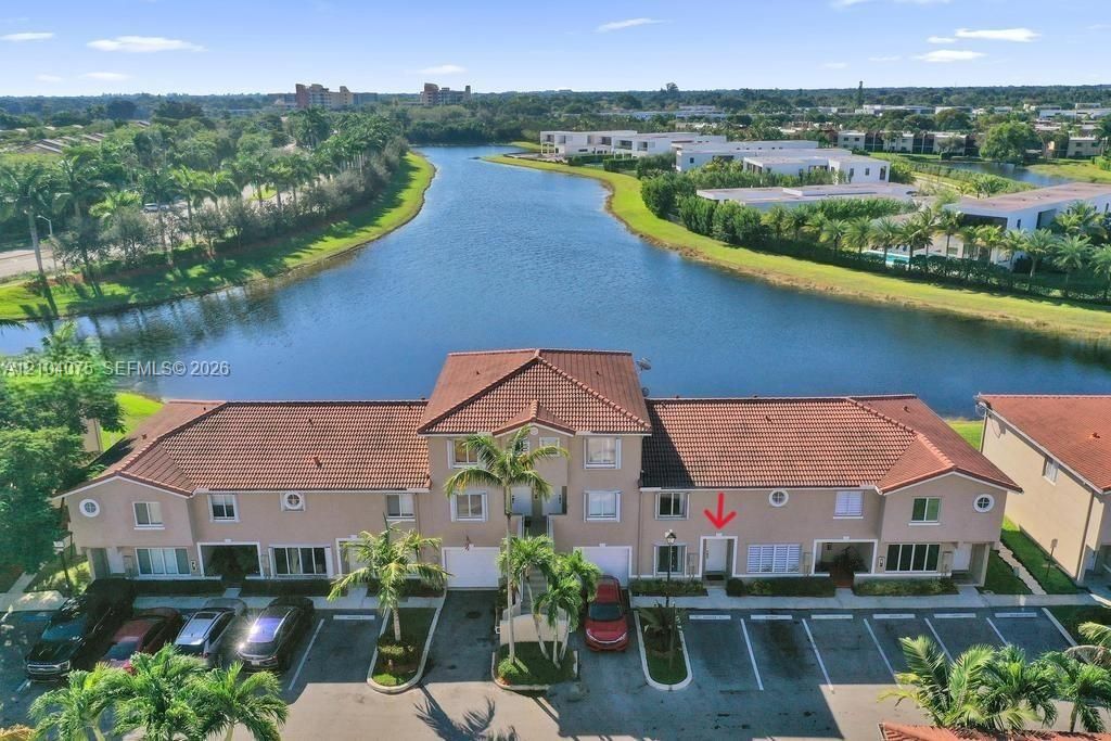 Multi-story stucco exterior featuring a tile roof and waterfront positioning