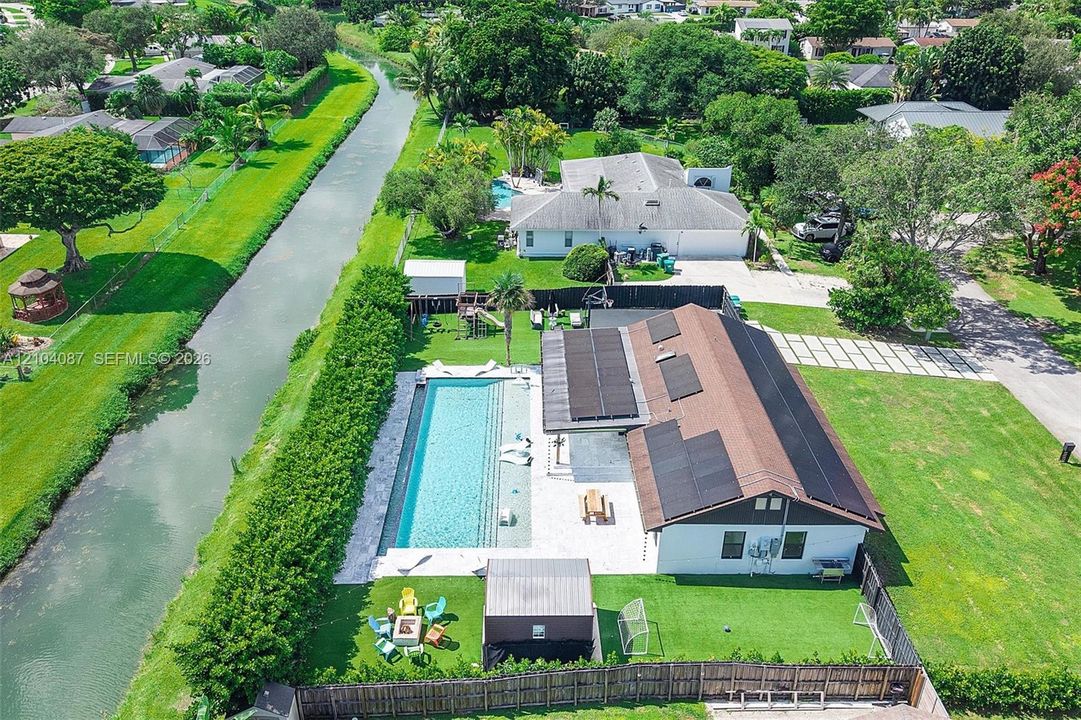 Exterior featuring a rectangular swimming pool, an expansive patio, and a dedicated artificial turf area