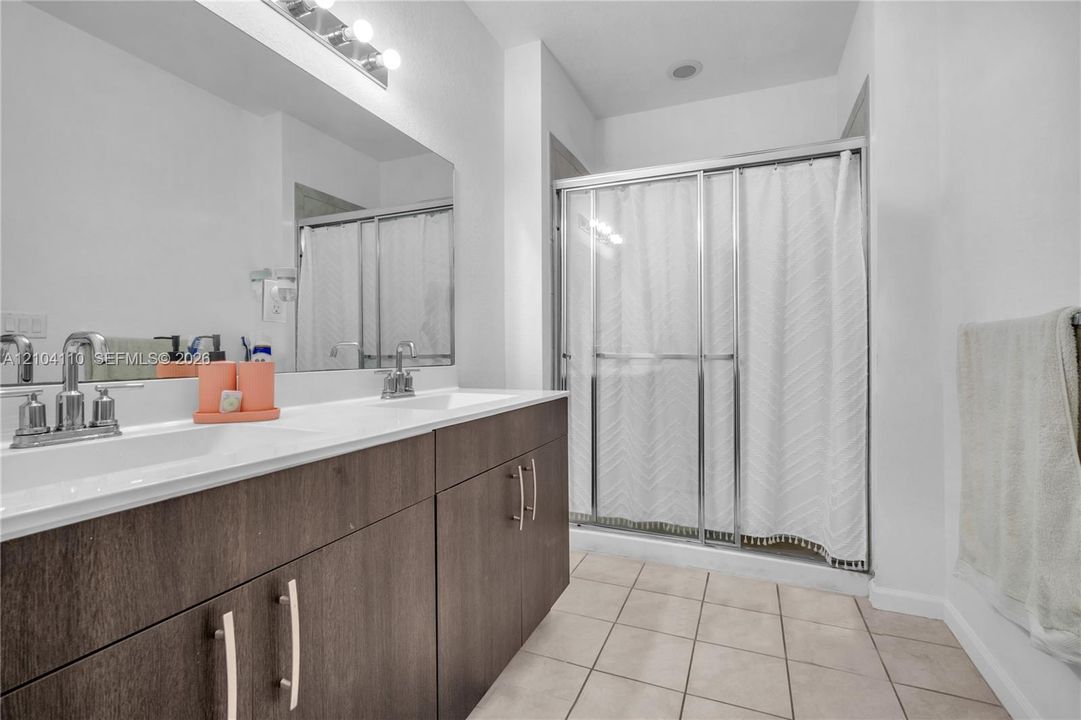 Dual vanity with chrome fixtures and dark wood-finish cabinetry