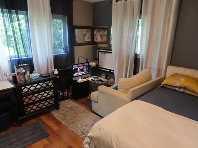 Room featuring wood-finish flooring and multiple windows providing natural light