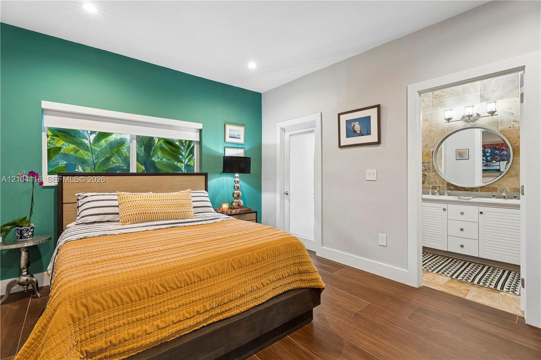 Wood-finish flooring throughout, with a recessed window and a fabric headboard