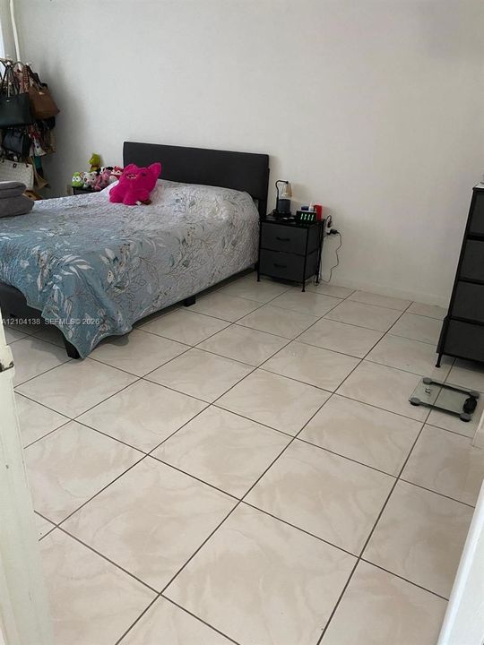 Room featuring large-format ceramic floor tiles and a neutral wall finish