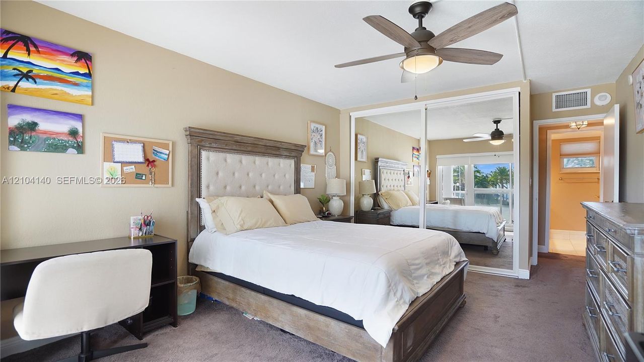 Room featuring a ceiling fan with integrated lighting and sliding mirrored closet doors