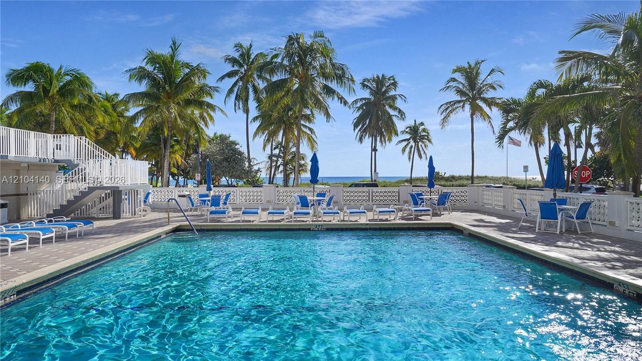 Rectangular swimming pool featuring tile coping, a multi-level paver deck, and decorative concrete balustrade perimeter fencing