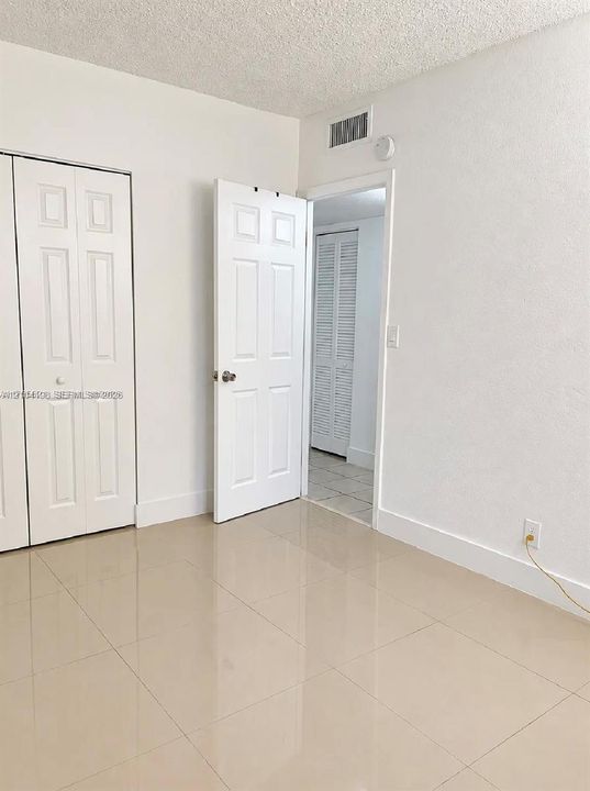 Neutral-toned tile flooring, bi-fold closet doors, and multi-panel interior doors