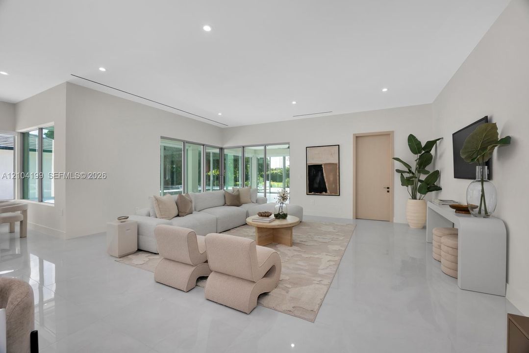 Spacious interior featuring large-format tile flooring, recessed lighting, expansive glass windows, and minimalist trim-less door frames