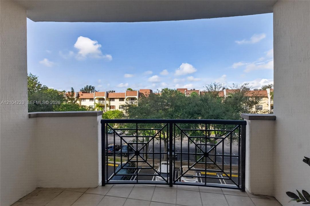 Covered balcony featuring tile flooring and a decorative metal railing