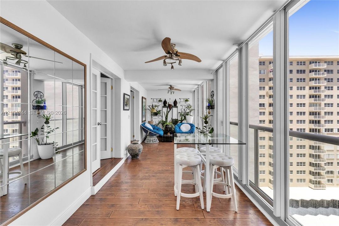 Enclosed balcony, floor-to-ceiling windows, full-wall mirrors, and dual ceiling fans