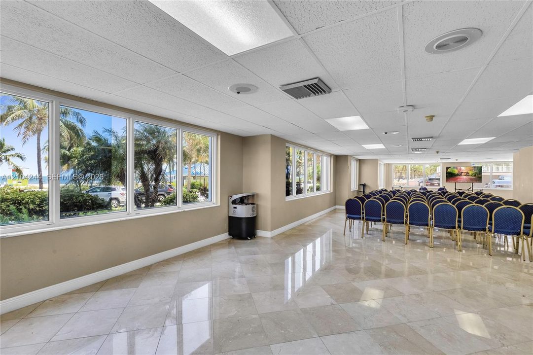 Open-concept interior featuring polished stone flooring, expansive floor-to-ceiling windows, and recessed ceiling lighting