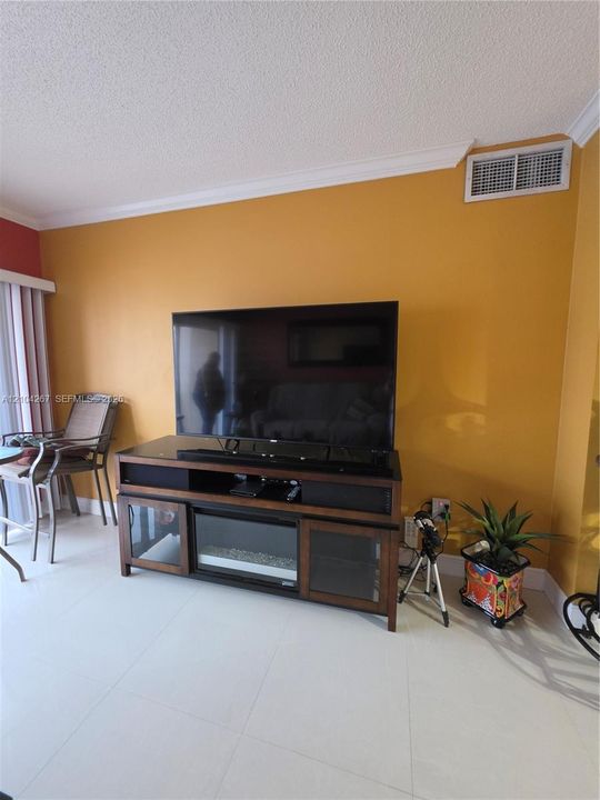Interior space featuring large-format tile flooring and crown molding