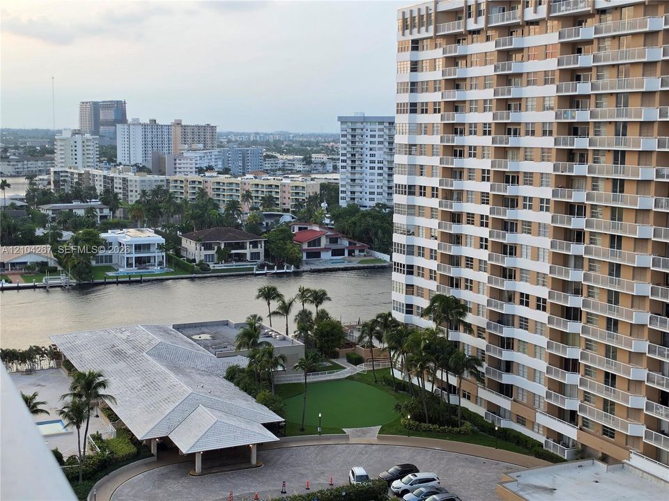 High-rise building featuring private balconies, integrated hardscaped motor court, manicured green space, and waterfront proximity