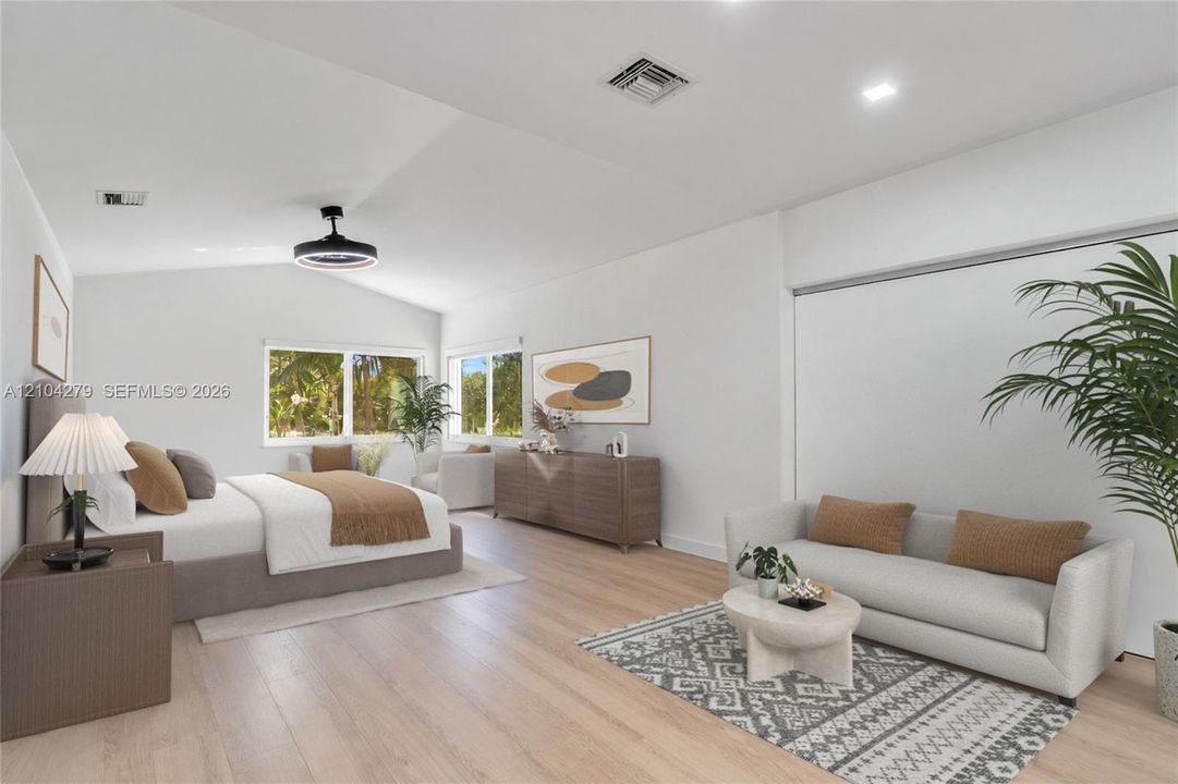 Spacious interior featuring wood-finish flooring, vaulted ceilings, recessed lighting, and multiple windows