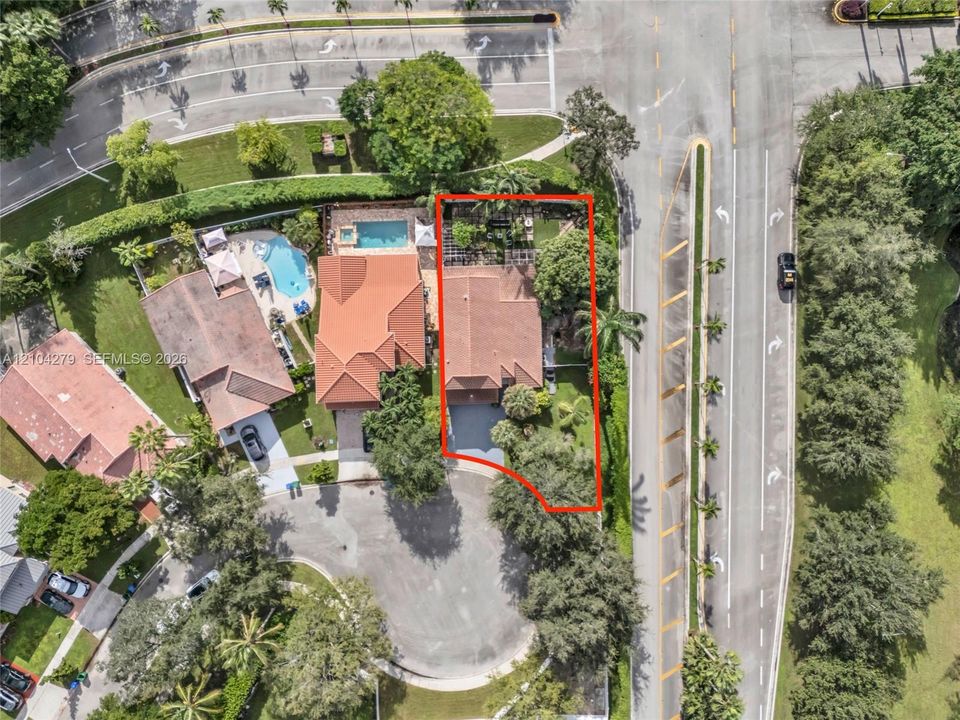 Aerial perspective of property featuring a tile roof, paved driveway, and established landscape