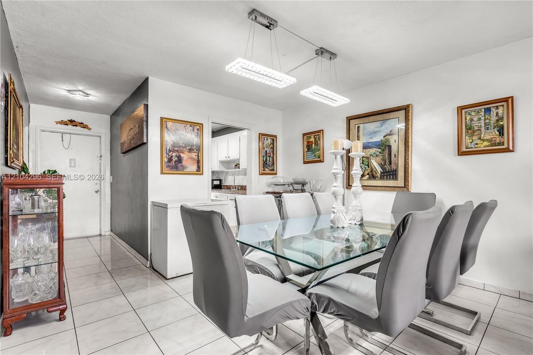 Dining area featuring large-format ceramic tile flooring and modern rectangular dual-pendant lighting with integrated LED illumination