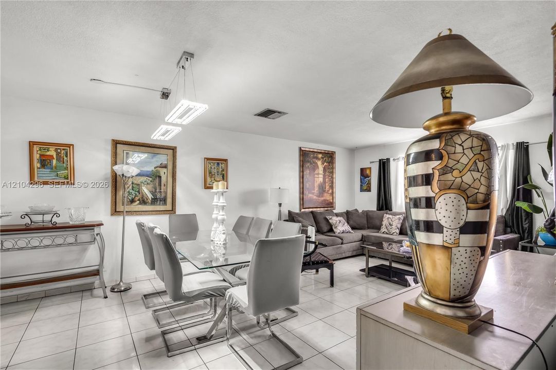 Open-concept interior featuring oversized tile flooring, modern dual-pendant rectangle lighting, and recessed ceiling lighting