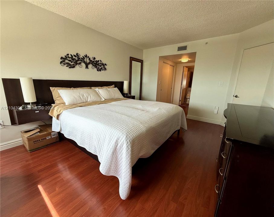 Wood-finish flooring and built-in headboard with integrated floating nightstands