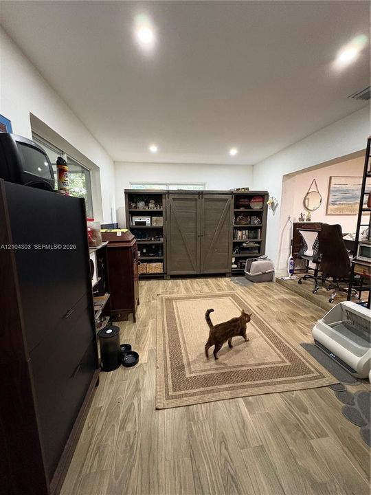 Interior space featuring wood-finish flooring, recessed lighting, and built-in cabinetry with sliding barn-style doors