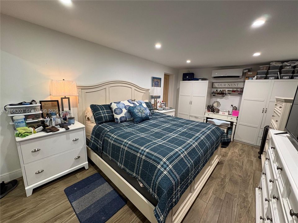 Wood-finish flooring, recessed ceiling lighting, and a wall-mounted ductless heating and cooling unit
