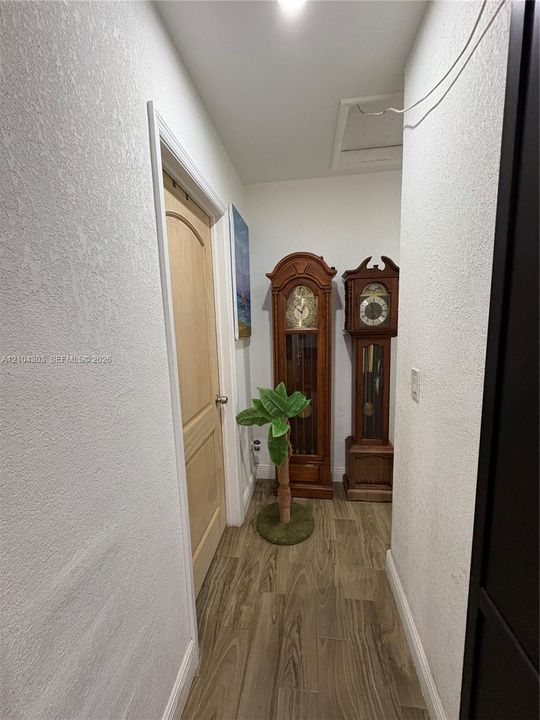 Hallway featuring textured wall finishes, wood-finish flooring, and a single-panel arch-top interior door