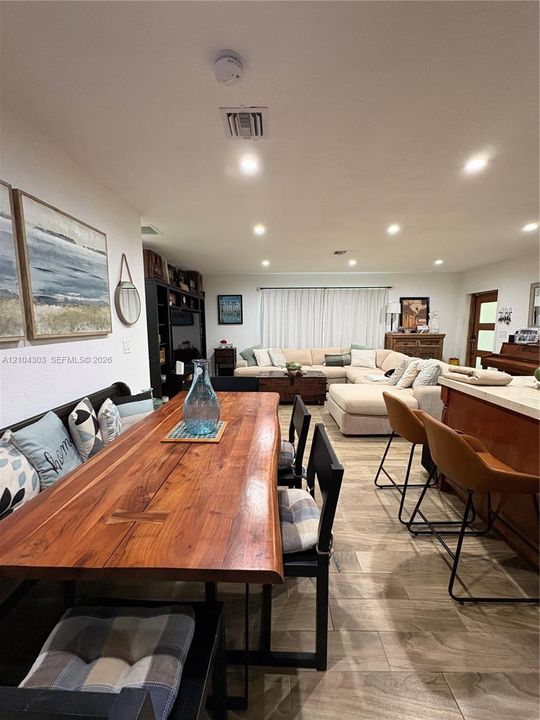 Open-concept interior featuring wood-finish tile flooring, recessed lighting, and built-in floor-to-ceiling cabinetry