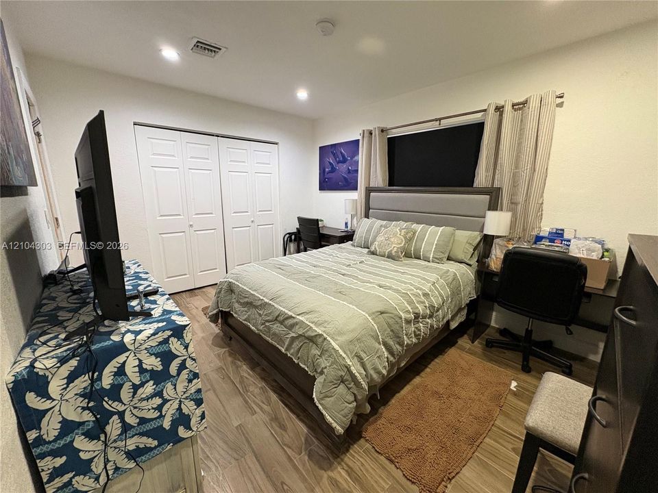 Wood-finish flooring, recessed lighting, and double-door reach-in closet