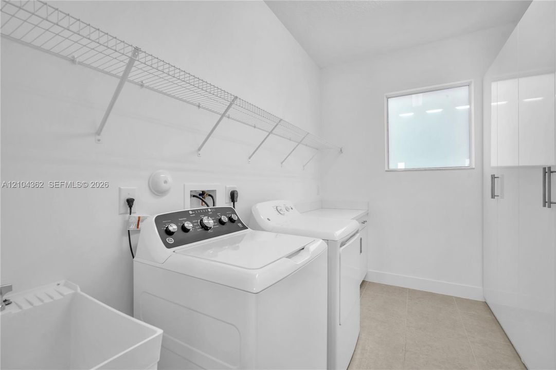 With utility sink, counter top folding cabinet and custom closets.