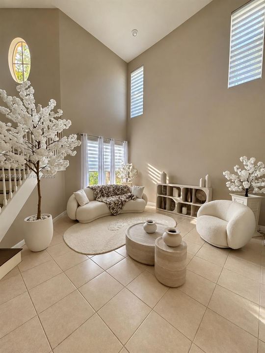Kitchen featuring white shaker-style cabinetry, a central island with a solid surface countertop, stainless steel appliances, and tile flooring