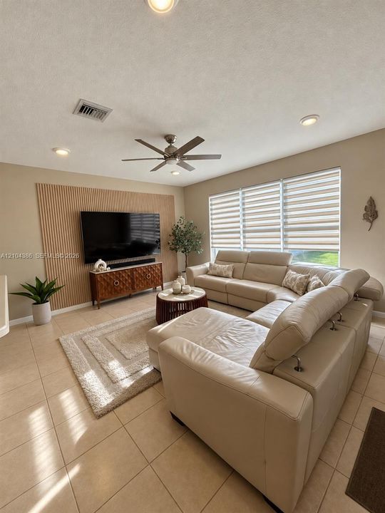 Vaulted ceilings, expansive multi-story windows, arched accent window, and wood-finish staircase treads