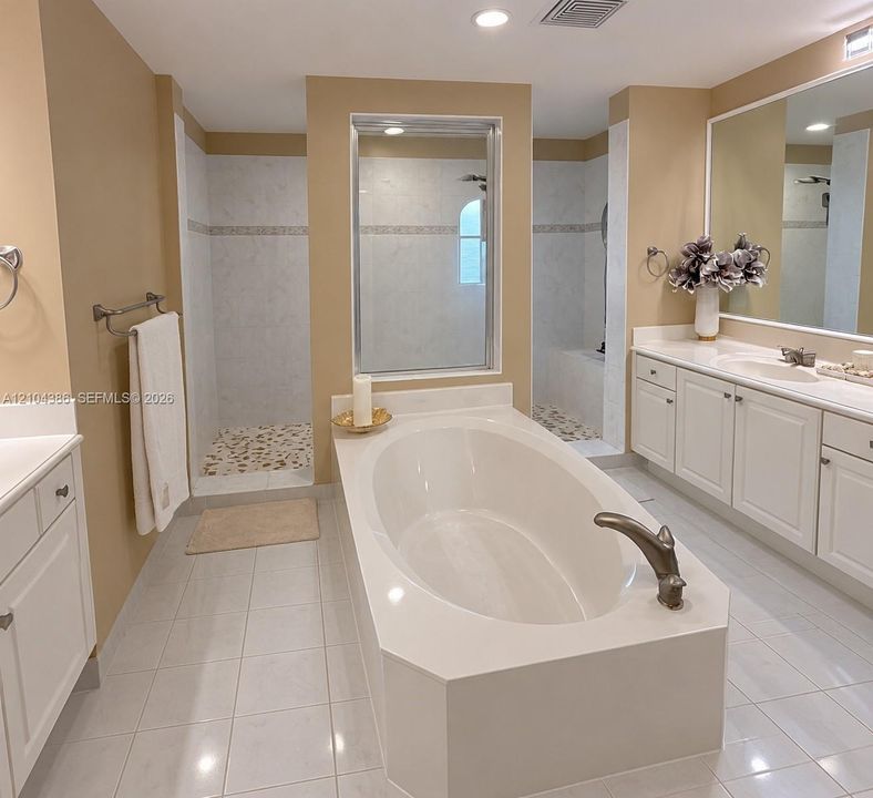 Room featuring wood-finish flooring, a multi-blade ceiling fan with integrated lighting, and a single window with layered treatments