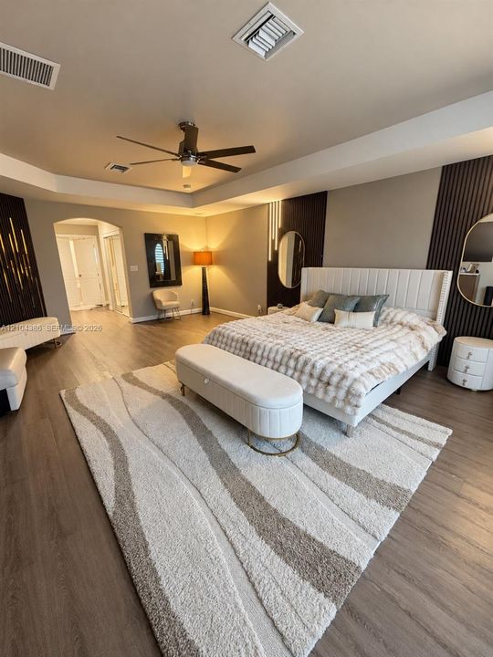 Walk-in closet featuring wood-finish flooring, built-in wire shelving, and an integrated multi-drawer storage unit