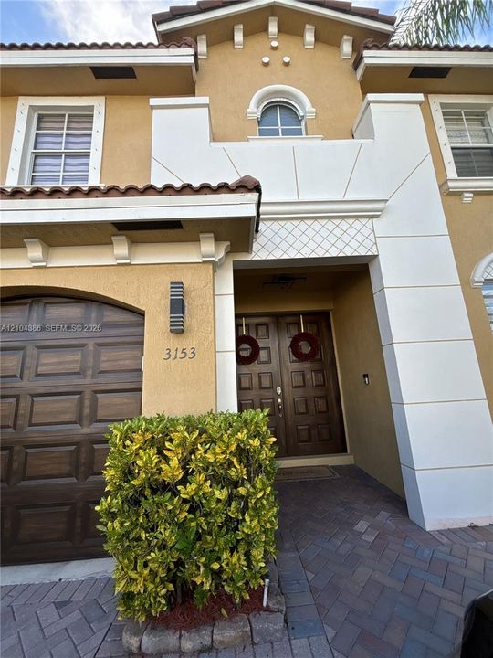 Foyer featuring double entry doors with square panel detailing, a prominent architectural archway, and neutral tile flooring