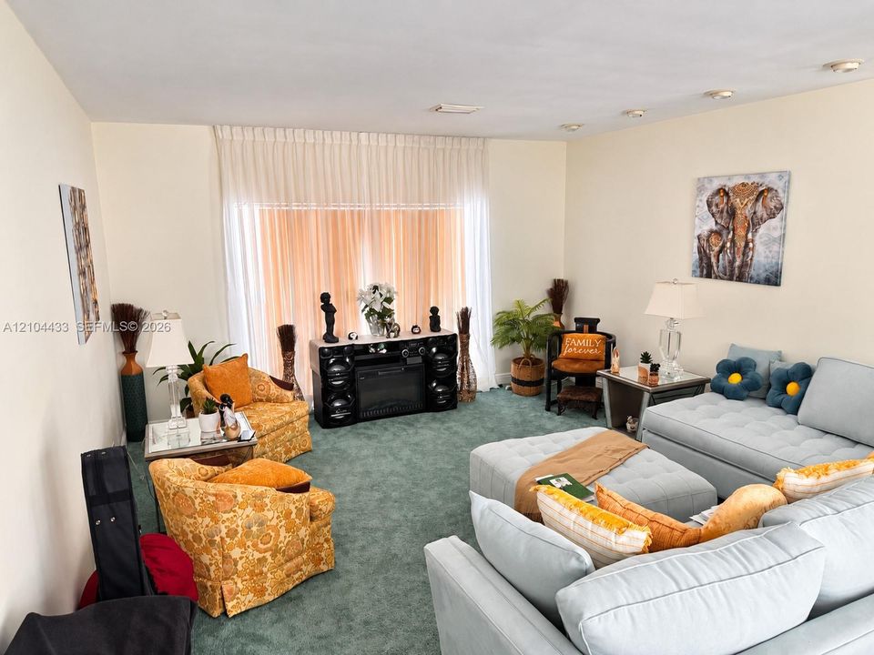 Recessed lighting illuminates this room featuring wall-to-wall carpeting and neutral wall finishes