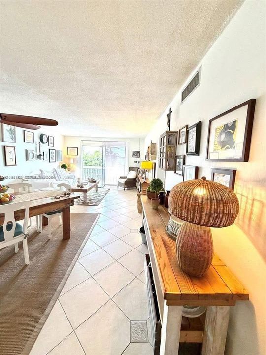 Open-concept space featuring diagonal ceramic tile flooring, a textured ceiling, and large sliding glass doors providing outdoor access