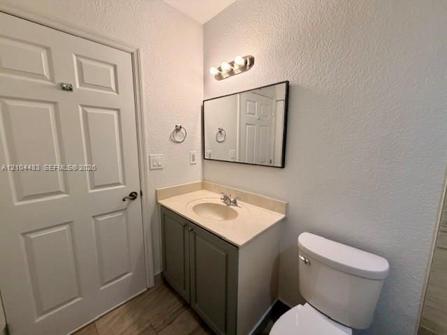 Vanity with integrated sink and chrome faucet, rectangular mirror with black frame, three-light vanity fixture, and a paneled interior door