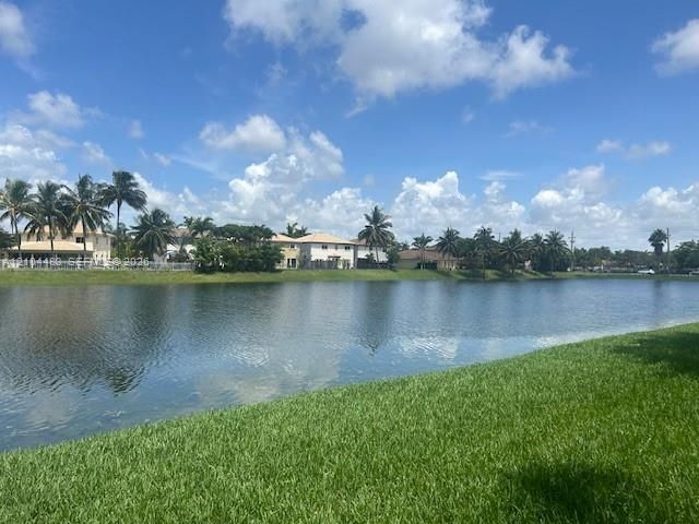 Expansive waterfront setting with lush green landscaping