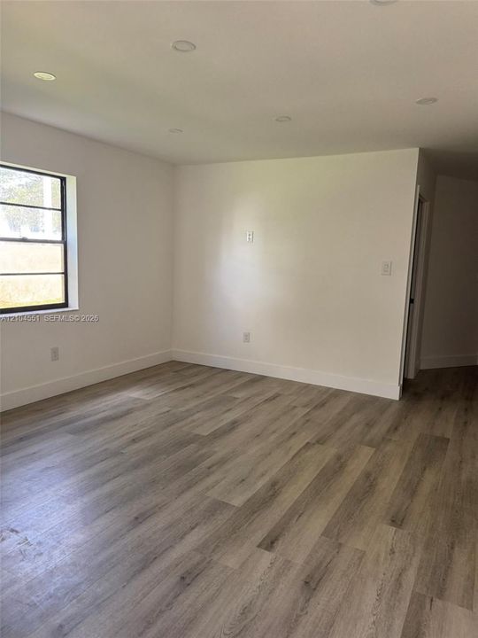 Interior space featuring wood-finish flooring, recessed lighting, and a single-pane window with black framing