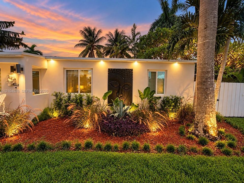 Exterior elevation featuring smooth stucco siding, low-profile soffit lighting, and custom relief wall art
