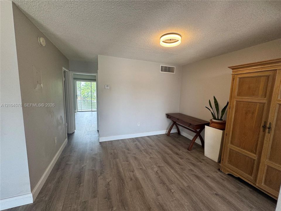 Neutral interior featuring wood-finish flooring and a circular flush-mount ceiling fixture
