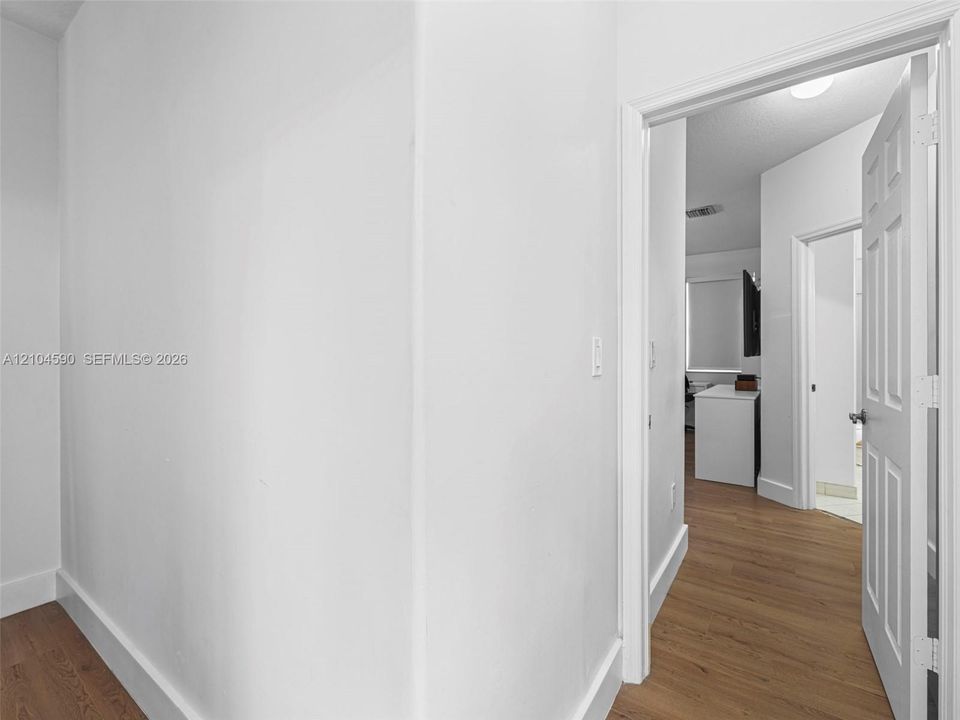 Wood-finish flooring, six-panel interior doors, and neutral wall paint