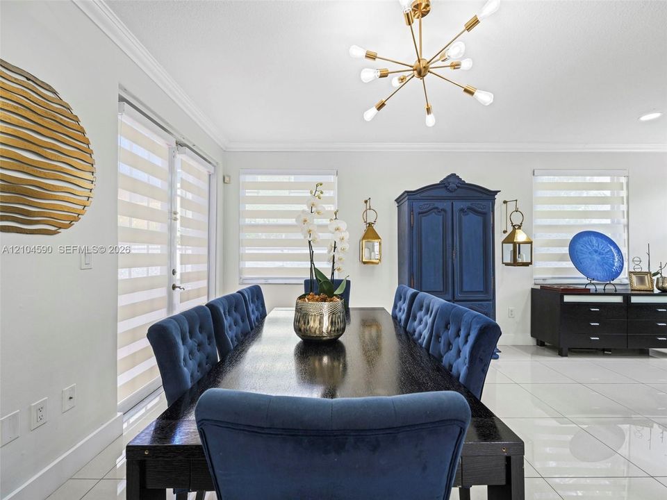 Large-format polished tile flooring, contemporary multi-arm metallic light fixture, and banded roller shades
