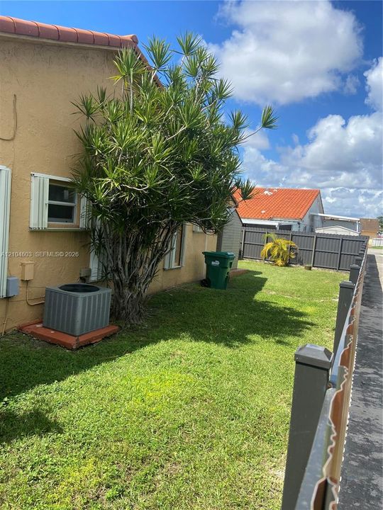 Rear exterior featuring an established tree, stucco siding, and a tile roof
