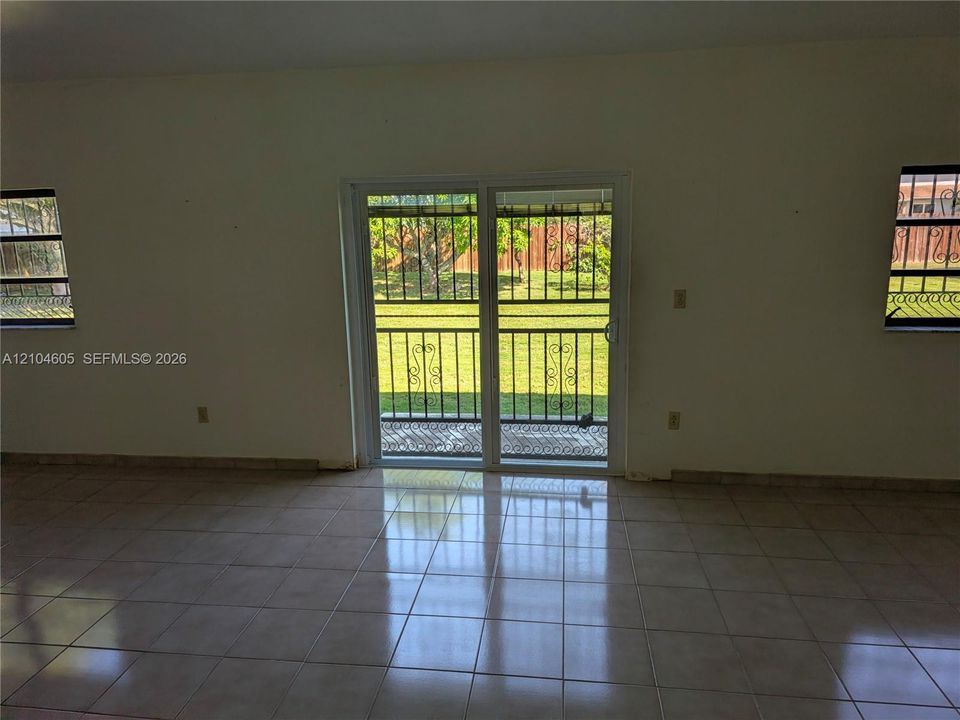 Ceramic tile flooring, sliding glass patio door, and exterior metal security grilles installed on all windows and door