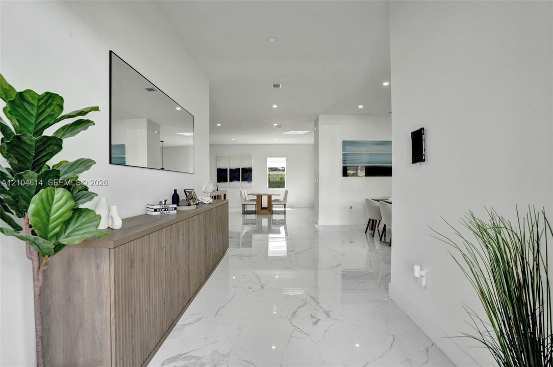 Expansive hallway with polished tile flooring, recessed lighting