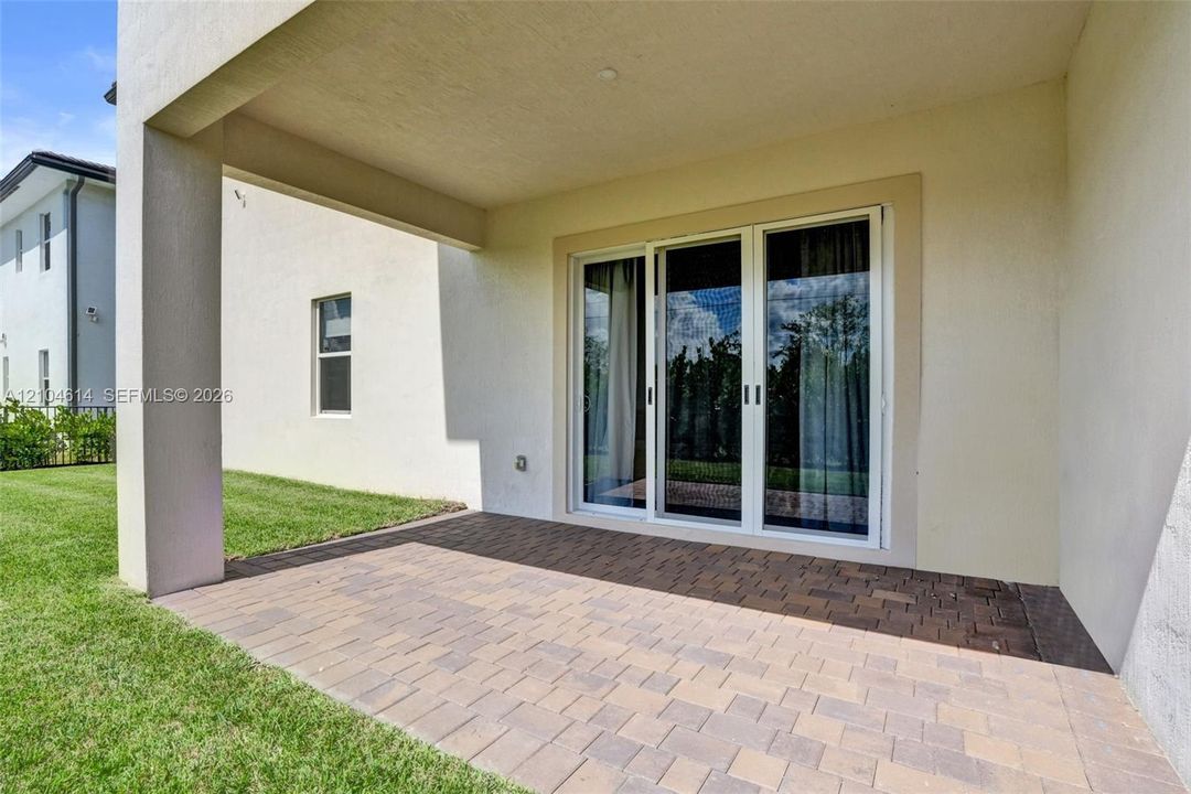 Covered patio area featuring a brick paver surface