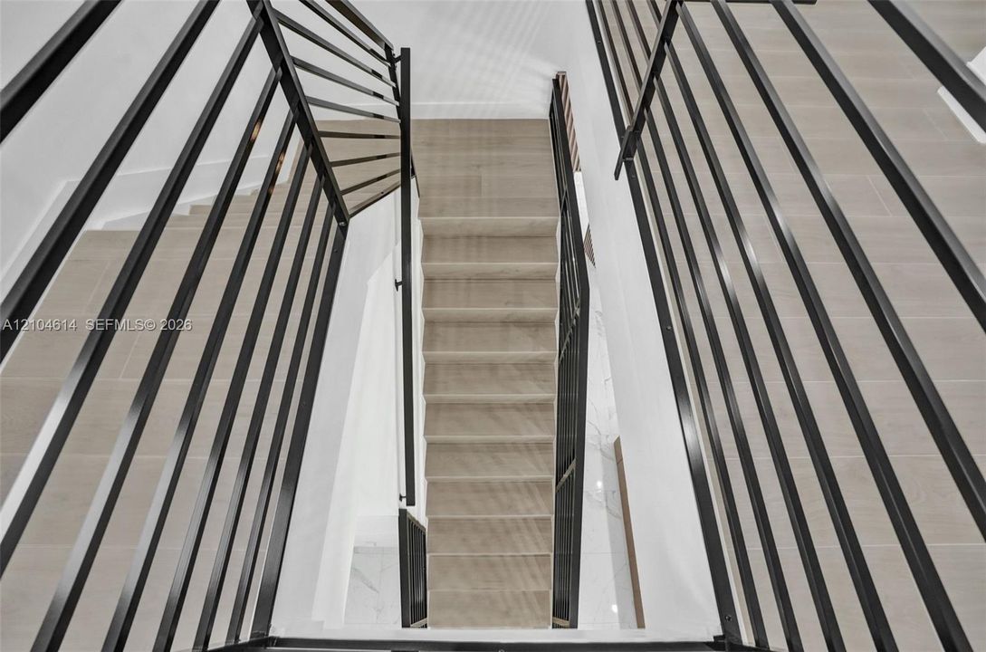 Multi-level staircase with contemporary black metal railings