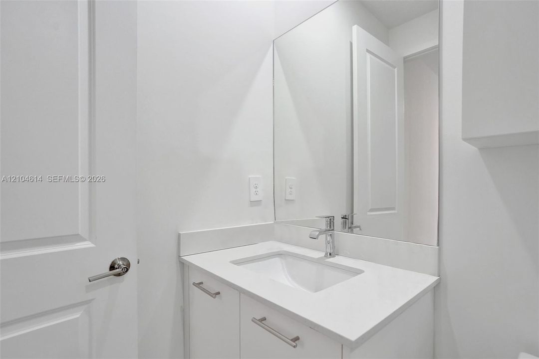Modern vanity with an integrated rectangular sink, chrome faucet, and substantial wall mirror